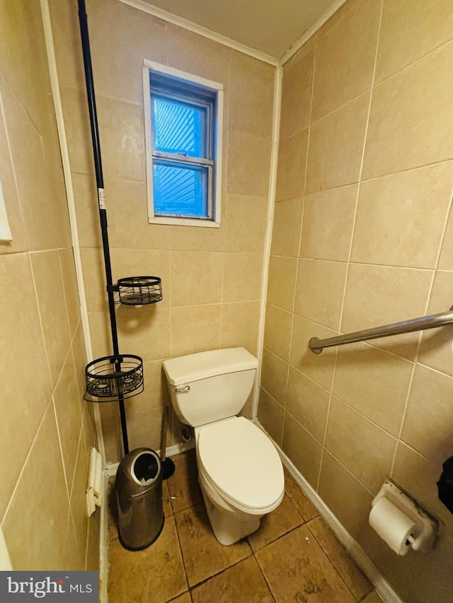 bathroom with tile patterned flooring, tile walls, toilet, and ornamental molding