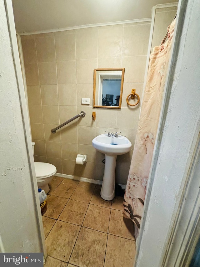 bathroom with toilet, tile patterned floors, tile walls, and a shower with shower curtain