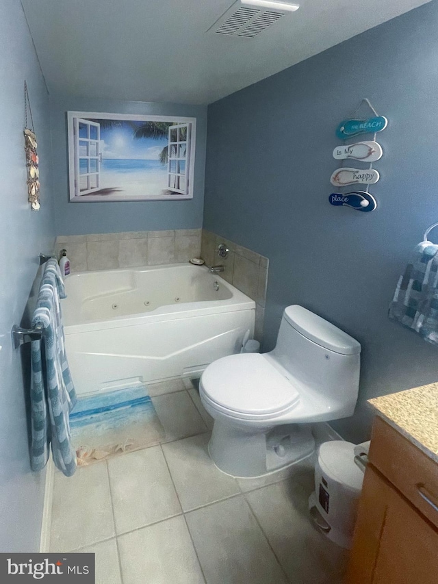 bathroom featuring toilet, vanity, a tub, and tile patterned flooring