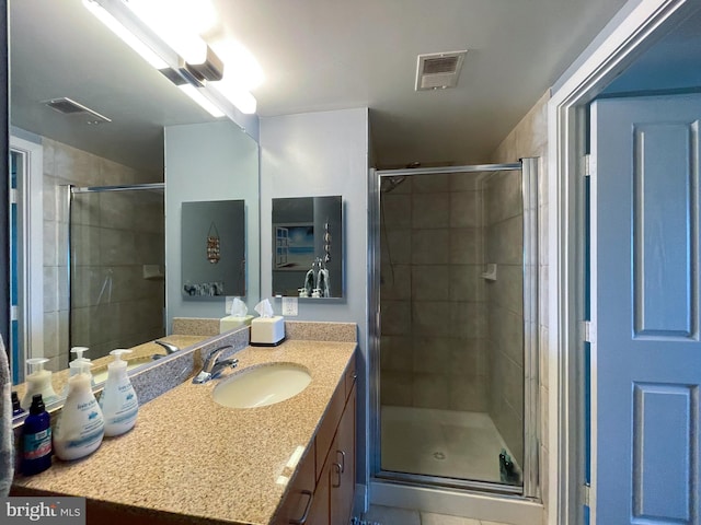 bathroom with a shower with door and vanity