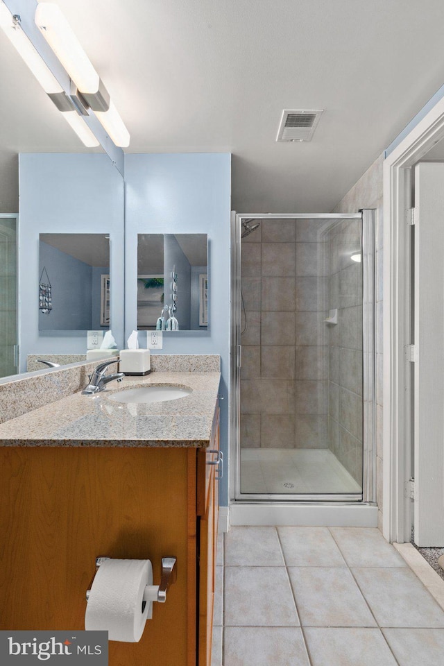 full bath with a stall shower, tile patterned flooring, and vanity