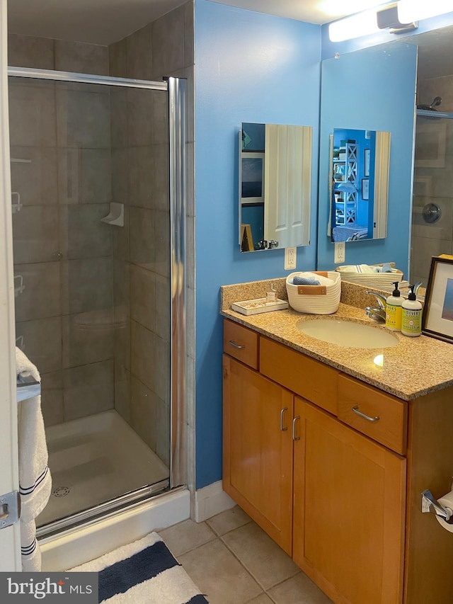 bathroom with walk in shower, vanity, and tile patterned flooring