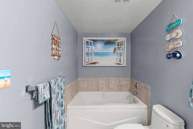 bathroom featuring toilet and a garden tub