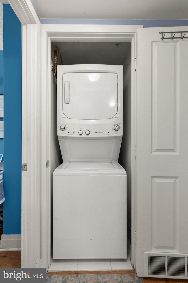 clothes washing area with stacked washer / dryer