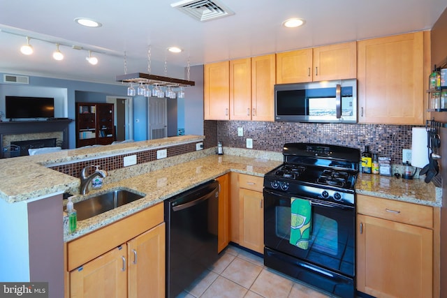 kitchen with light stone countertops, sink, black appliances, and kitchen peninsula