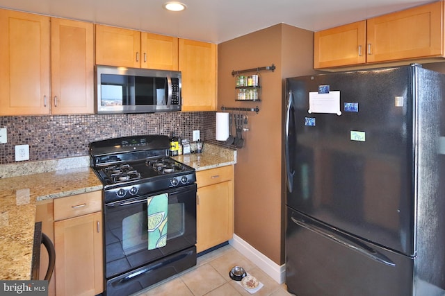 kitchen with black appliances, light tile patterned floors, backsplash, light stone countertops, and light brown cabinets