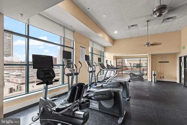 workout area with a drop ceiling, a towering ceiling, and ceiling fan