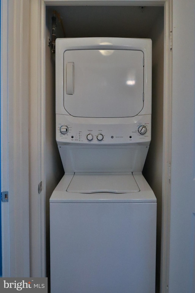 laundry room featuring stacked washer / drying machine