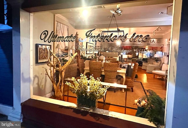 dining area featuring ornamental molding, hardwood / wood-style flooring, and indoor bar