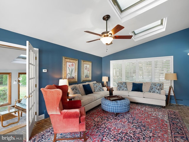 living room featuring lofted ceiling with skylight and ceiling fan