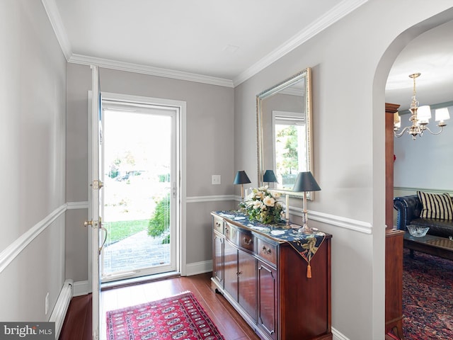 entryway featuring ornamental molding, an inviting chandelier, and hardwood / wood-style floors