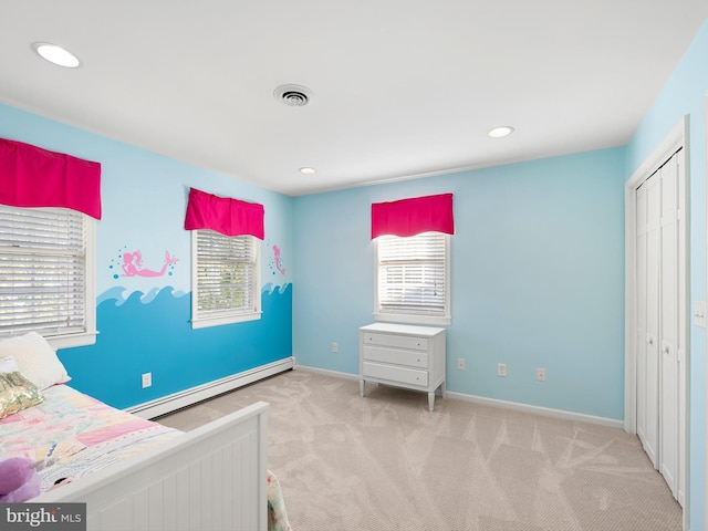 carpeted bedroom with a closet and baseboard heating