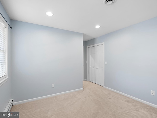 carpeted spare room featuring baseboard heating