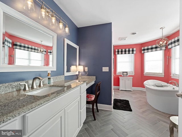 bathroom featuring vanity, a tub, and parquet floors