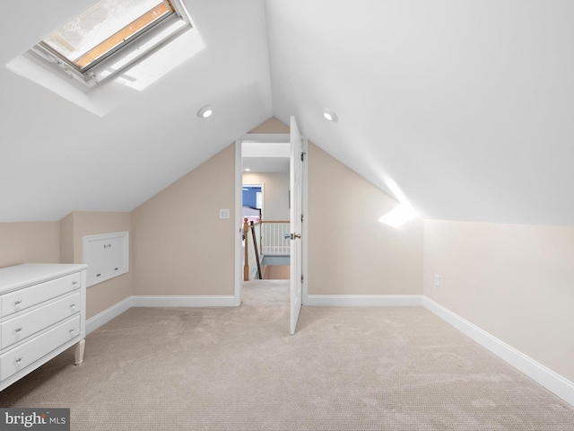 additional living space with lofted ceiling with skylight and light colored carpet