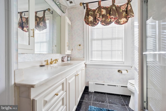 bathroom with vanity, baseboard heating, toilet, and a wealth of natural light