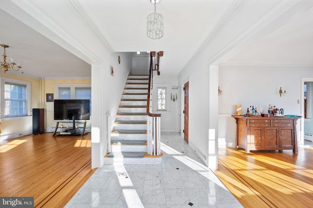 foyer with light hardwood / wood-style floors, crown molding, a chandelier, and bar