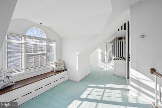 living area with light carpet, a baseboard radiator, and vaulted ceiling