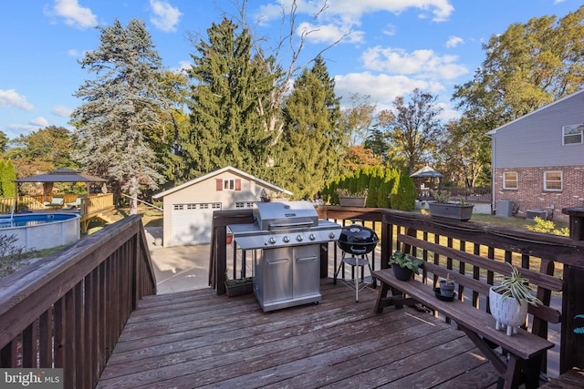 wooden deck with a fenced in pool, an outdoor structure, a garage, and a grill