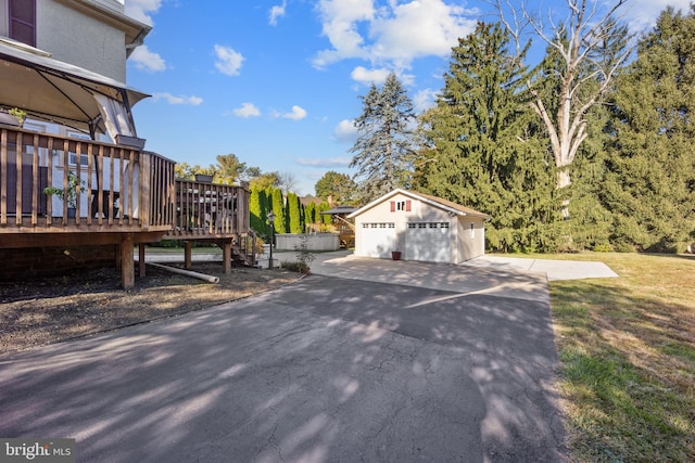 view of yard with an outdoor structure, a deck, and a garage