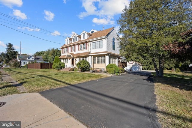 view of front facade with an outdoor structure, a garage, and a front lawn