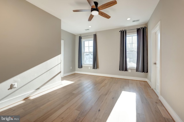 empty room with ceiling fan and light hardwood / wood-style floors