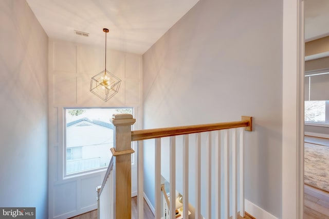 stairs with a notable chandelier