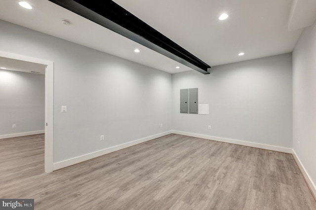 unfurnished room with beam ceiling and light hardwood / wood-style floors