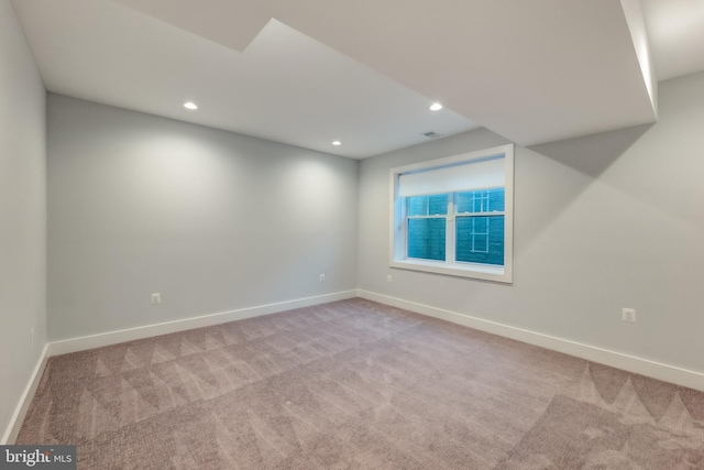 unfurnished room featuring light carpet