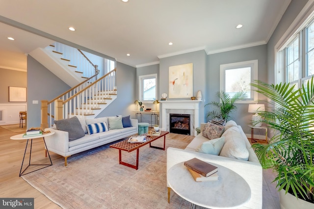 living room with crown molding and light hardwood / wood-style floors