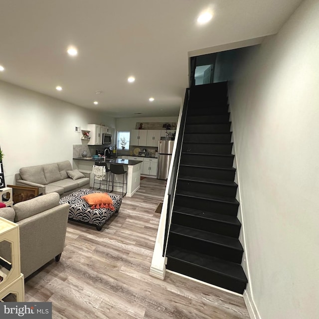 living room with light hardwood / wood-style floors and sink