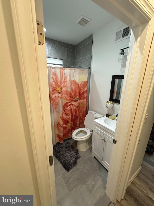 bathroom with vanity, curtained shower, wood-type flooring, and toilet