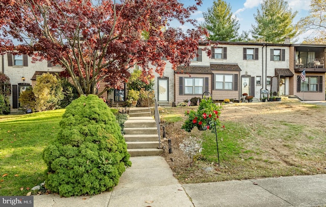 view of property featuring brick siding and a front yard