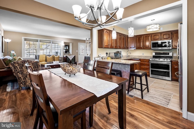 dining area featuring a notable chandelier and light hardwood / wood-style floors