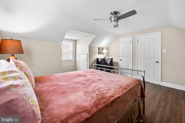 bedroom featuring multiple closets, vaulted ceiling, ceiling fan, and dark hardwood / wood-style floors