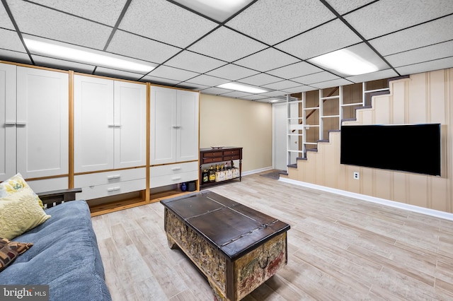 living room with a paneled ceiling and light hardwood / wood-style floors