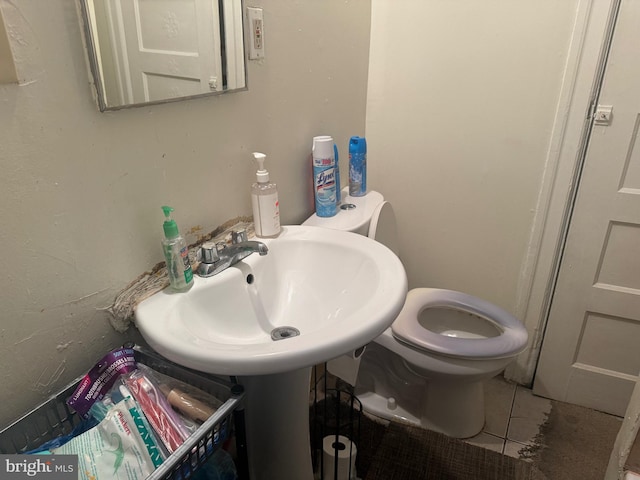 bathroom with sink, toilet, and tile patterned flooring