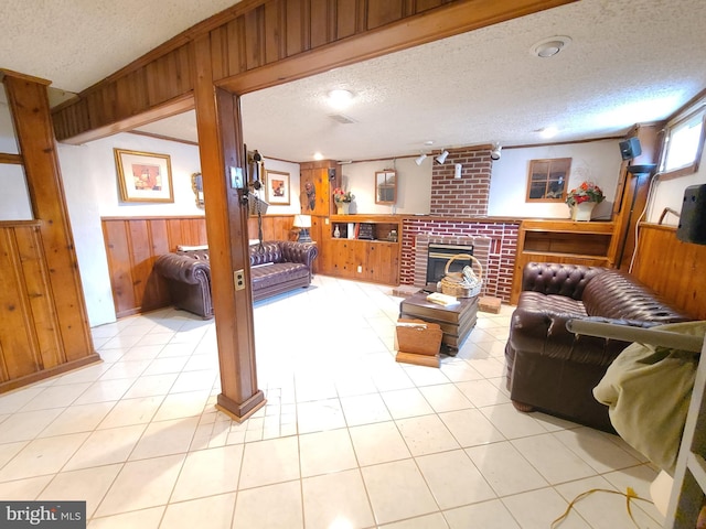 living room featuring light tile patterned floors, a textured ceiling, and wood walls