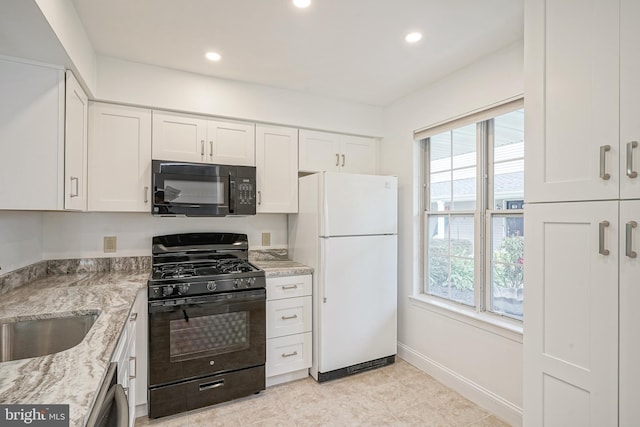 kitchen featuring light stone countertops, black appliances, white cabinets, and light tile patterned floors