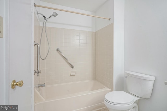 bathroom featuring tiled shower / bath and toilet