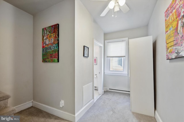 hall featuring a baseboard radiator and light colored carpet