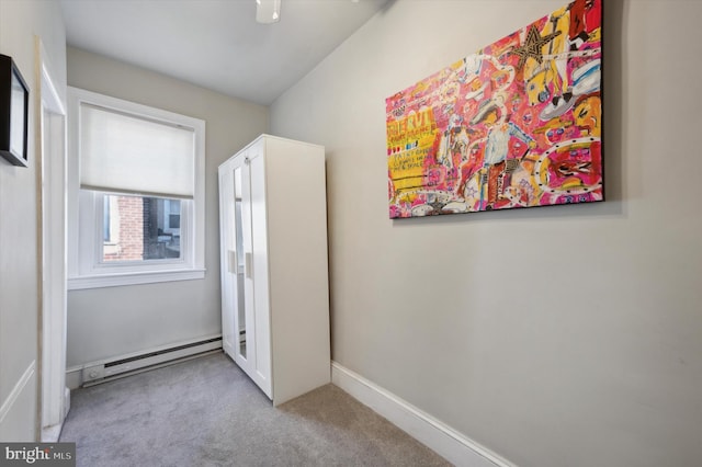 interior space featuring a baseboard heating unit, light carpet, and ceiling fan