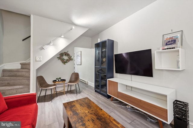 living room with hardwood / wood-style flooring and track lighting