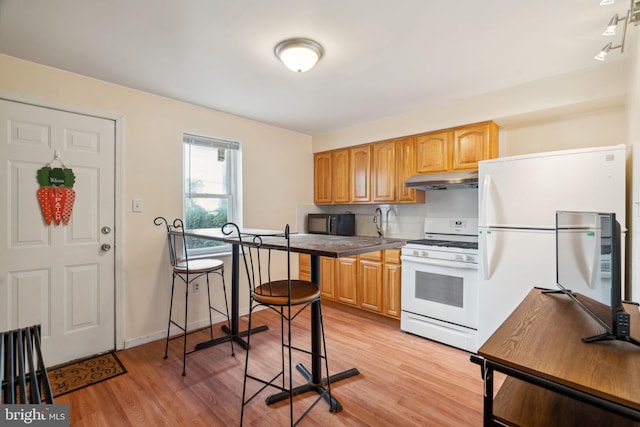 kitchen featuring white appliances and light wood-type flooring