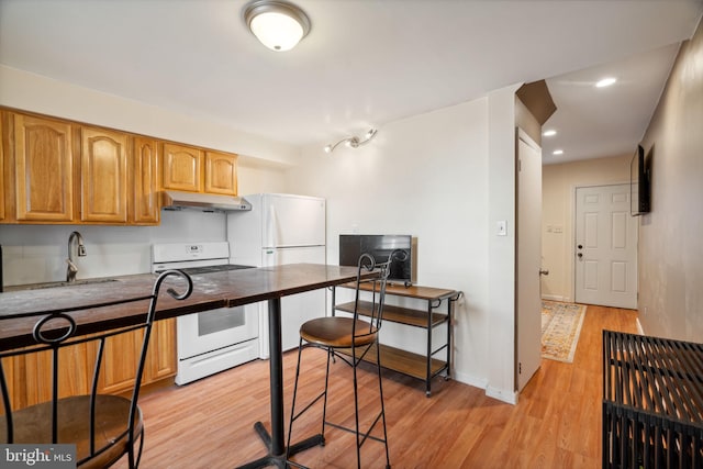 kitchen featuring light hardwood / wood-style floors, sink, and white appliances