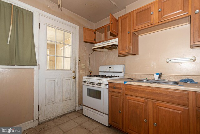 kitchen with sink, white range with gas cooktop, and light tile patterned floors