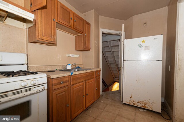 kitchen with sink, white appliances, and light tile patterned floors