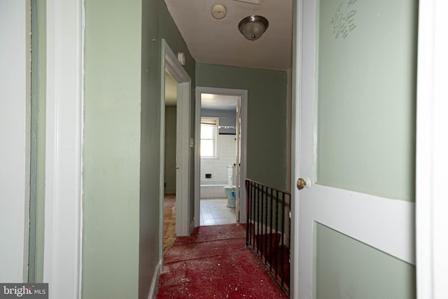 corridor with tile patterned floors and tile walls