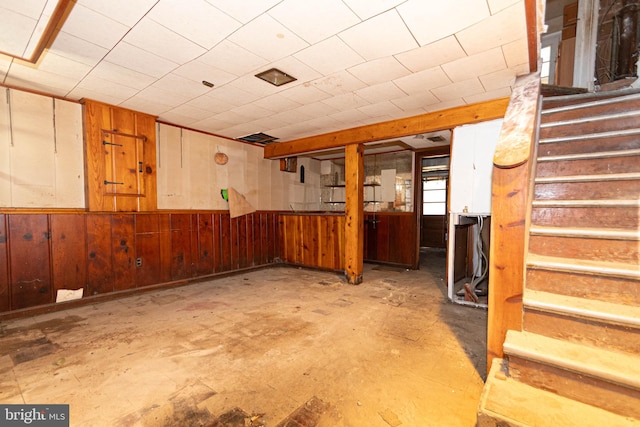 basement featuring wood walls