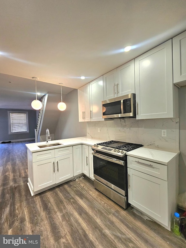 kitchen with sink, kitchen peninsula, hanging light fixtures, stainless steel appliances, and white cabinets